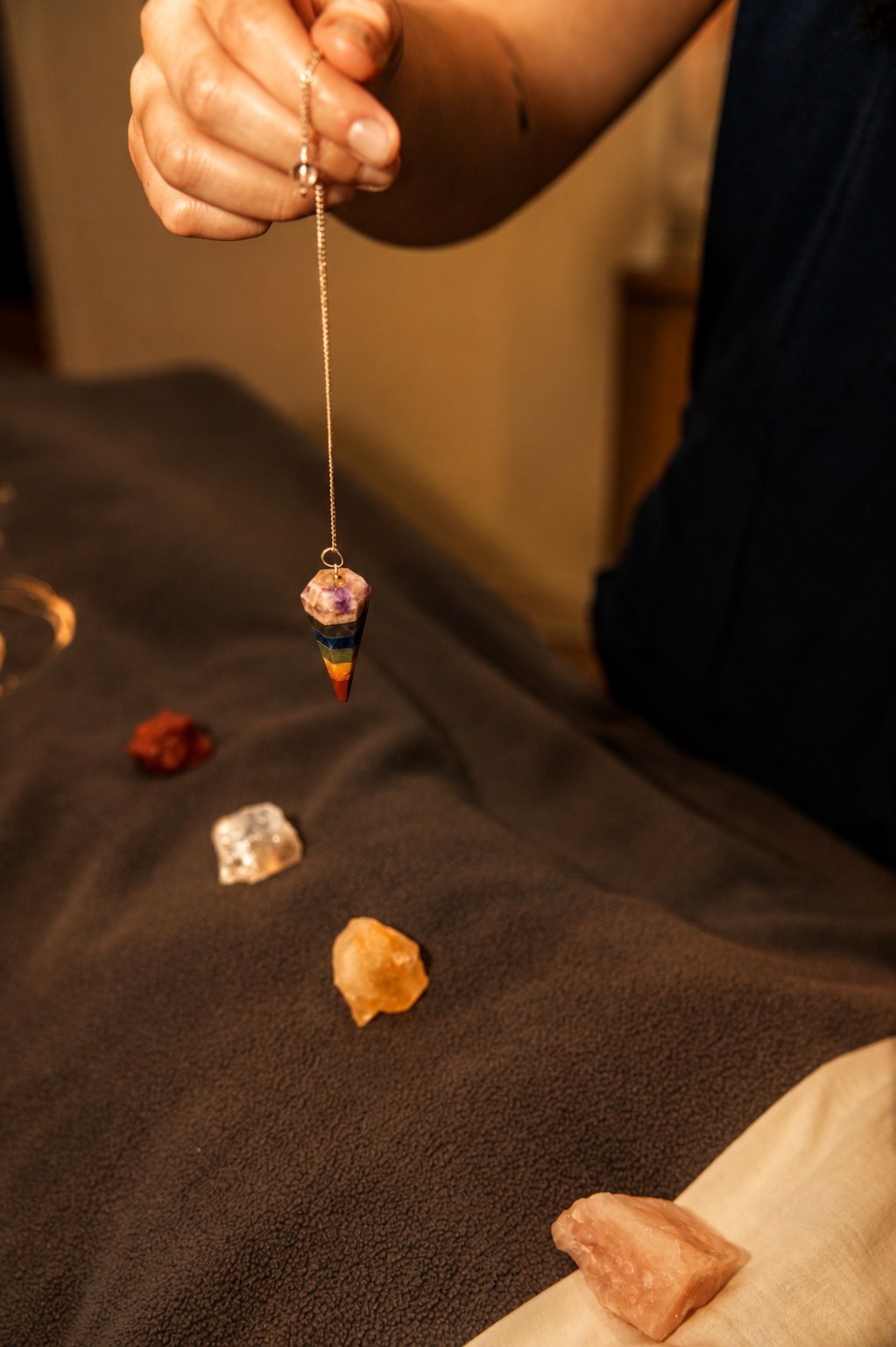 Chakra pendulum and crystals arranged for a session