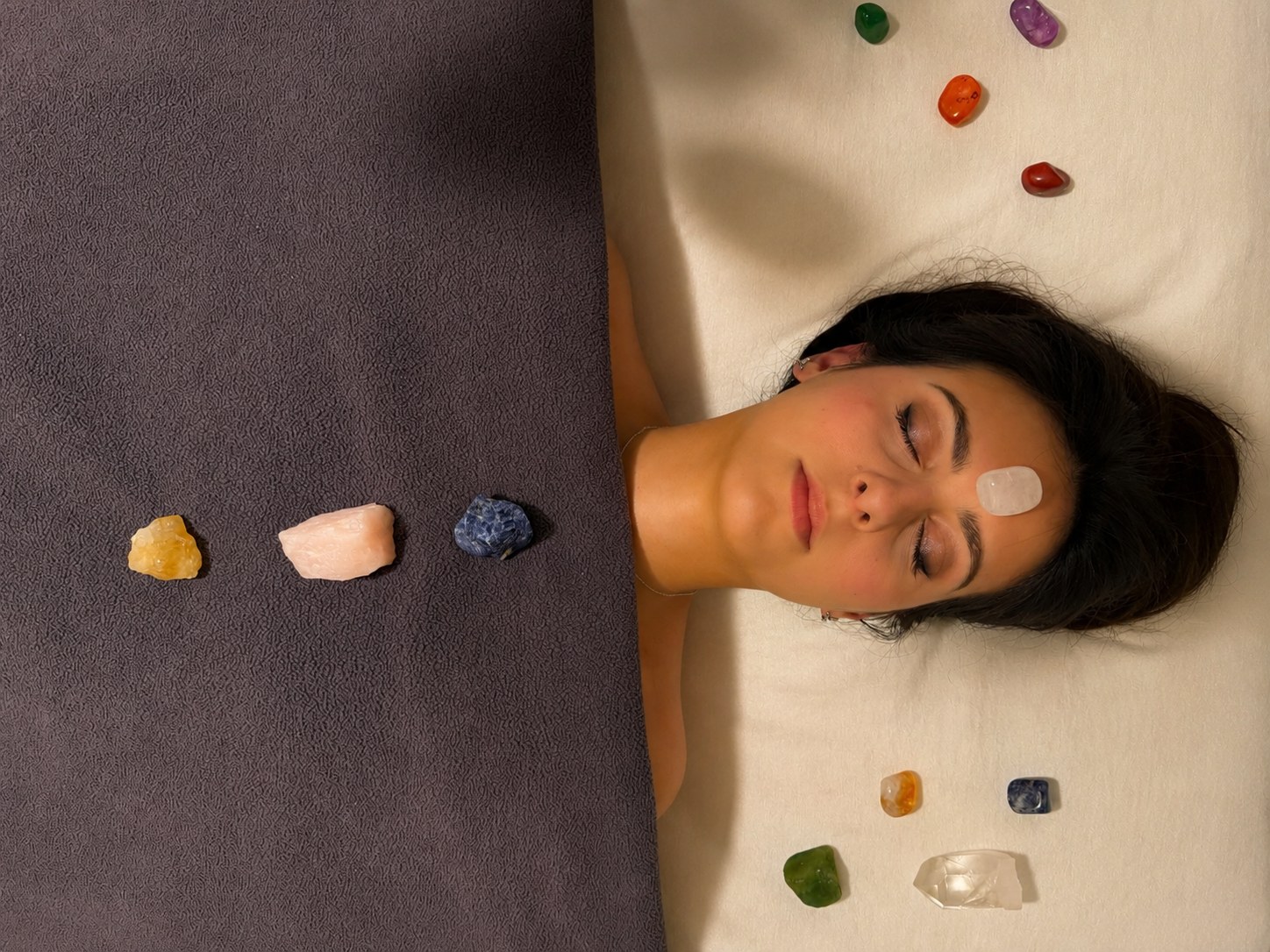 Crystals placed along a resting client's body during chakra balancing in Portsmouth, NH