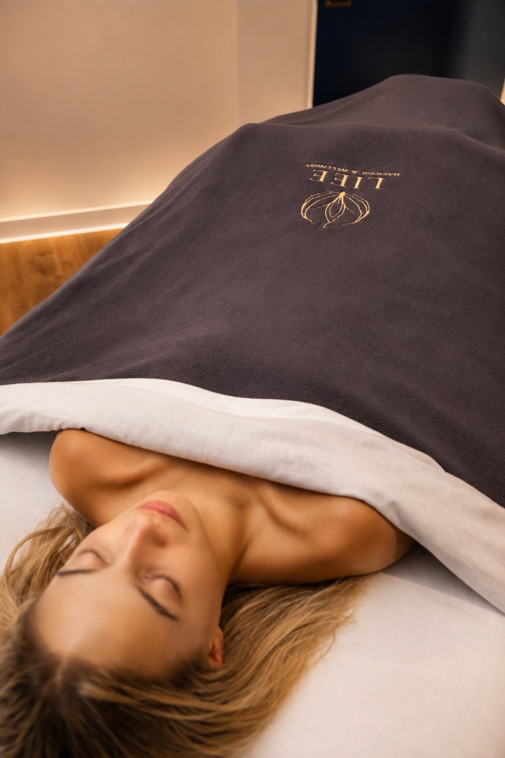 Deep rest under a warm blanket during a wrap session
