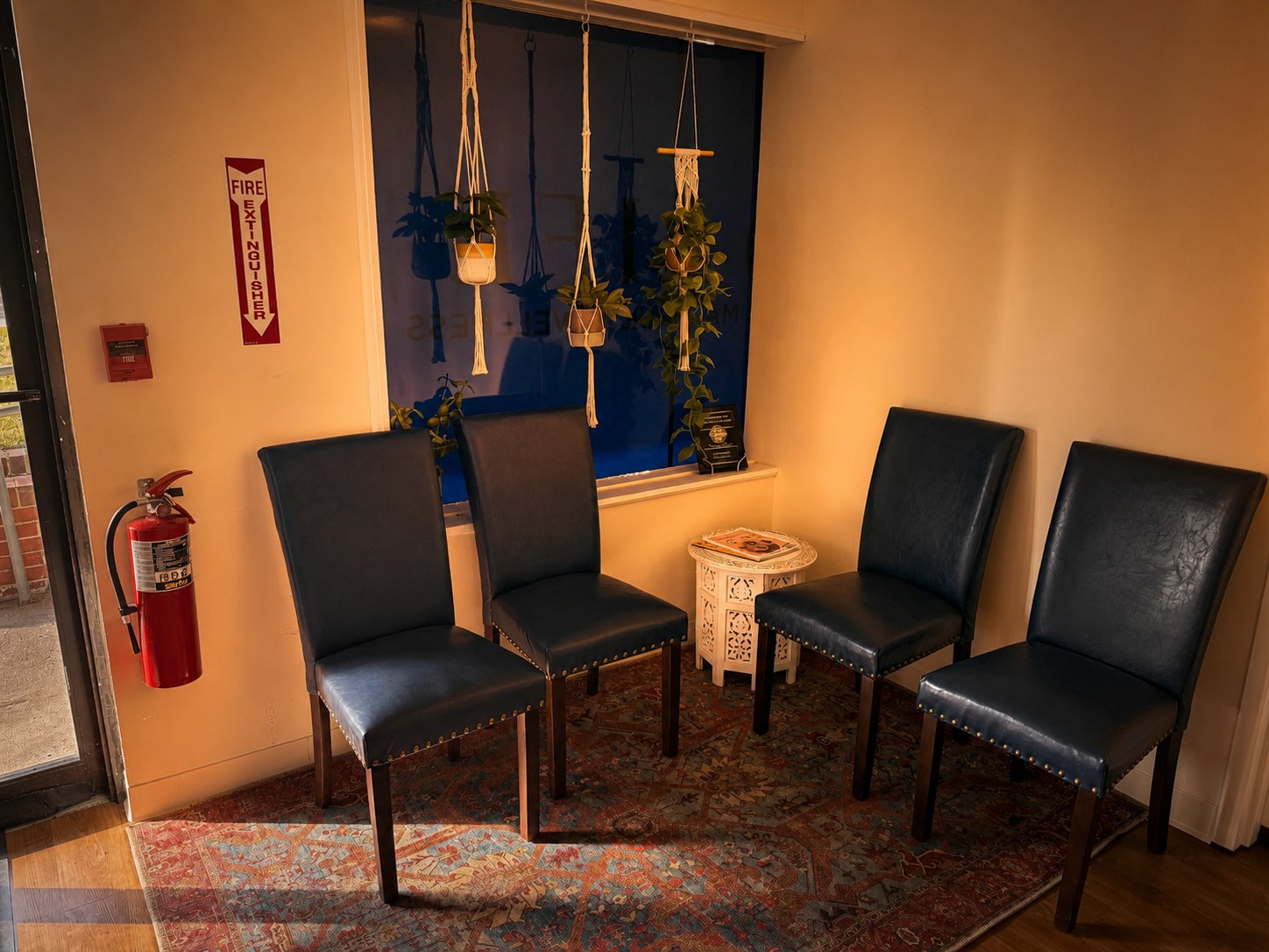 Bright waiting area with navy chairs and plants at the Portsmouth massage studio